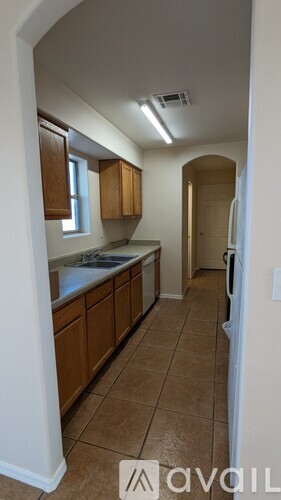 A kitchen with brown cabinets and a white fridge.
