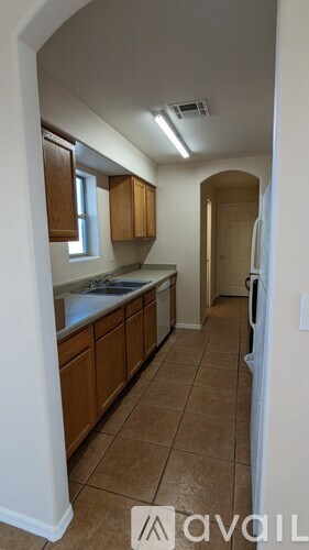A kitchen with brown cabinets and a white fridge.