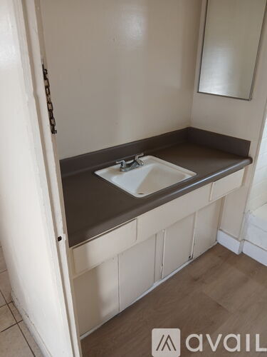 A bathroom sink with a brown counter top and white tiles.