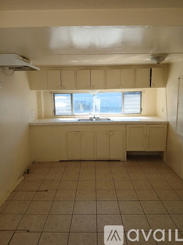 A room with beige cabinets and tiled flooring.