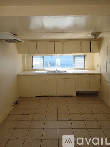 A room with beige cabinets and tiled flooring.