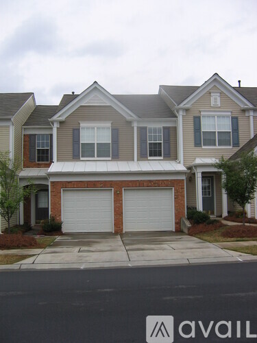 A house with a garage door in front of it.