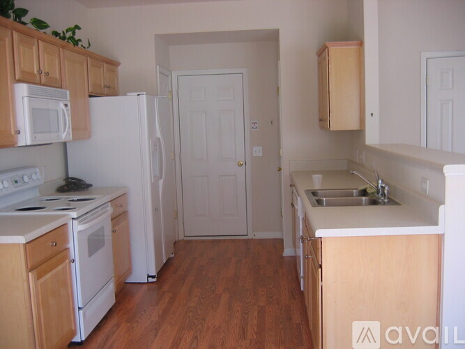 A kitchen with wooden cabinets and white appliances.
