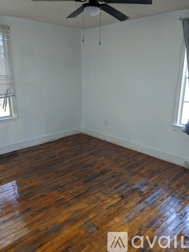 A room with wooden flooring and a ceiling fan.