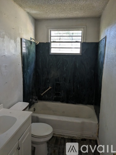 A bathroom with a toilet, sink, and bathtub.