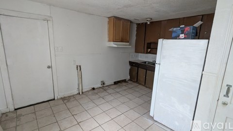 A kitchen with a white refrigerator and white tiled floor.