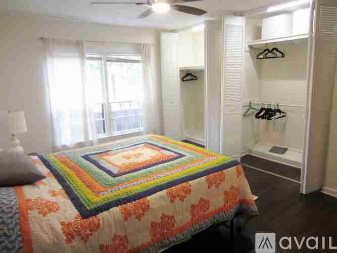 A bedroom with a bed, a window, and a closet.