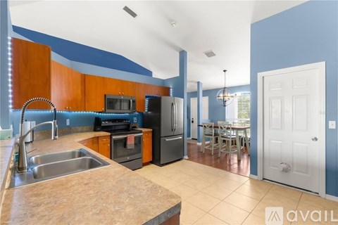A kitchen with blue walls and wooden cabinets.