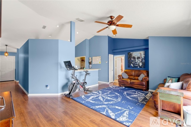 A living room with a blue rug and a brown chair.
