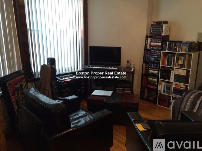 A living room with a TV, a chair, and a bookshelf.