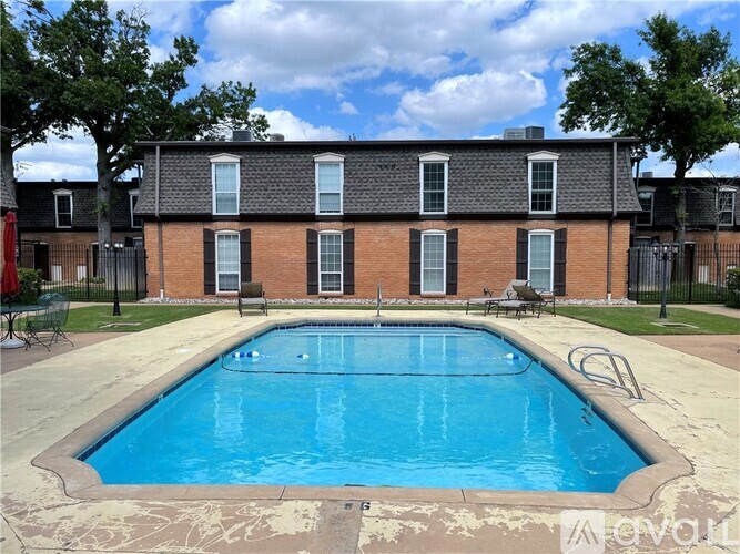 A swimming pool in front of a brick building.
