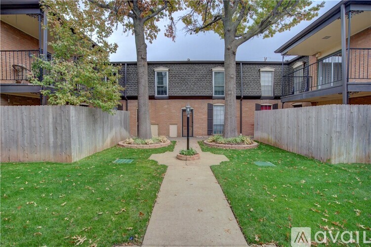 A courtyard with a walkway in the middle and apartment buildings on either side.
