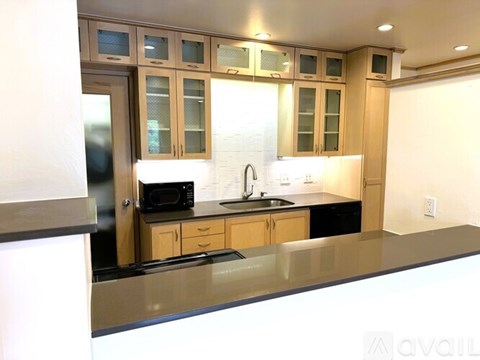 A kitchen with wooden cabinets and a black countertop.