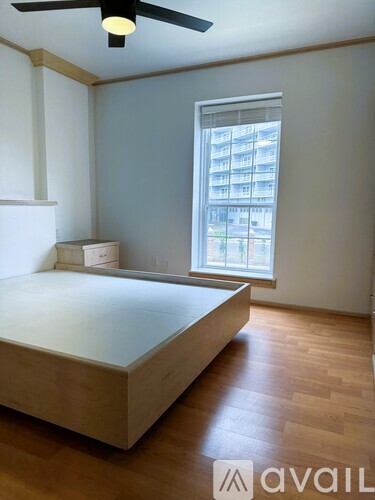 A bedroom with a bed, dresser, and window.