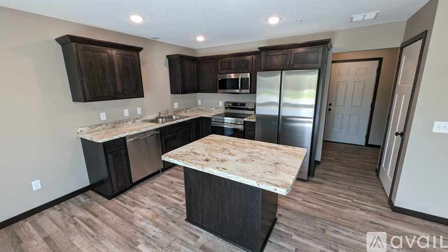 A kitchen with dark wood cabinets and a marble countertop.