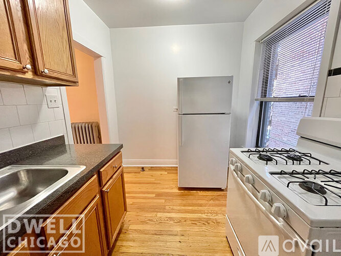 A kitchen with a stove, sink, and refrigerator.
