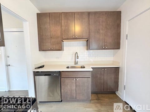 A kitchen with a stove, sink, and refrigerator.