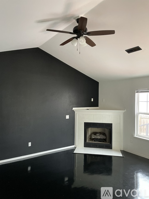 A room with a fireplace and a ceiling fan.