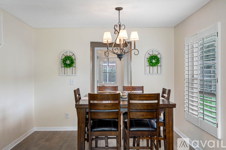 A dining room with a wooden table and chairs.