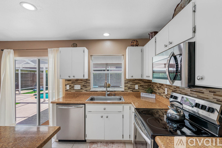 A kitchen with white cabinets and a black stove top.