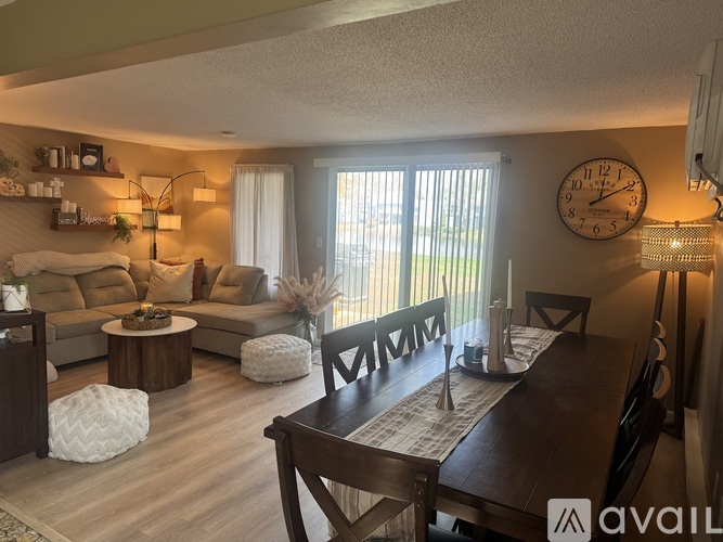 A living room with a couch, coffee table, and a dining table with chairs.
