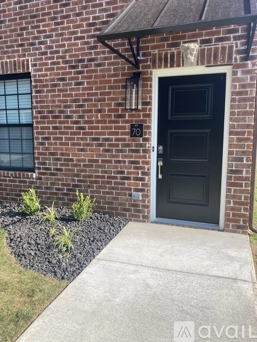A black door with a number 70 on the wall above it.