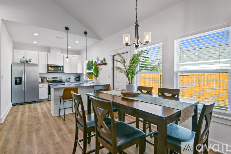 A modern kitchen with a dining table and chairs.