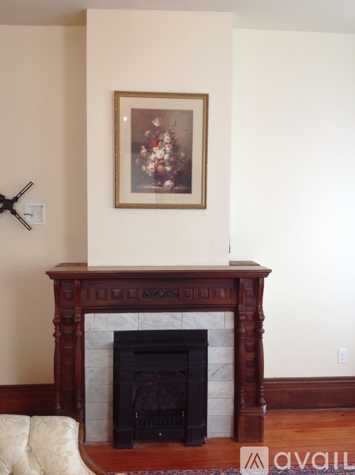 A fireplace with a painting above it and a clock on the wall.