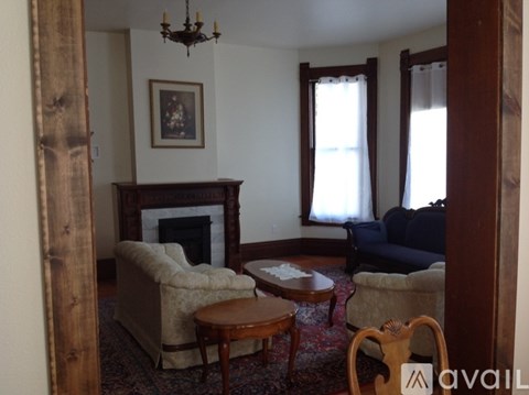 A living room with a fireplace and a painting on the wall.