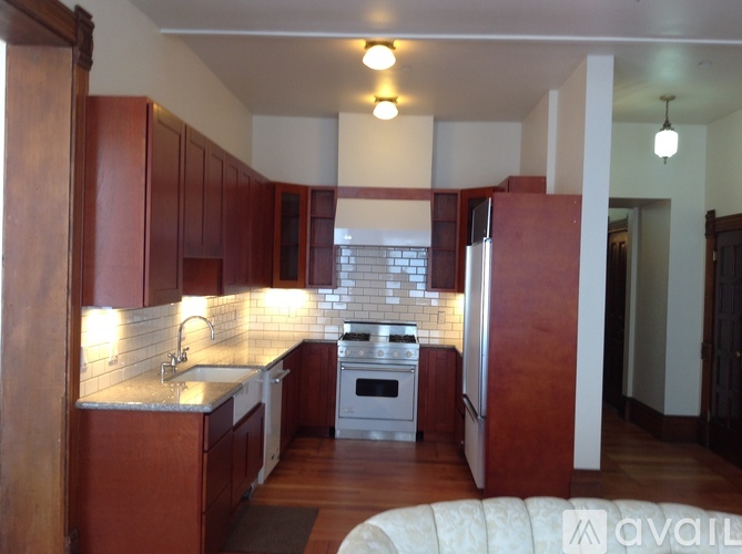 A kitchen with wooden cabinets and a white stove top oven.