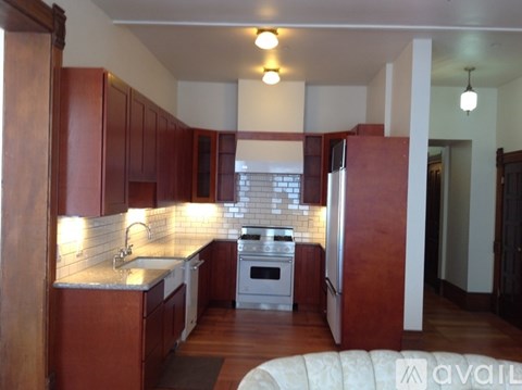A kitchen with wooden cabinets and a white stove top oven.