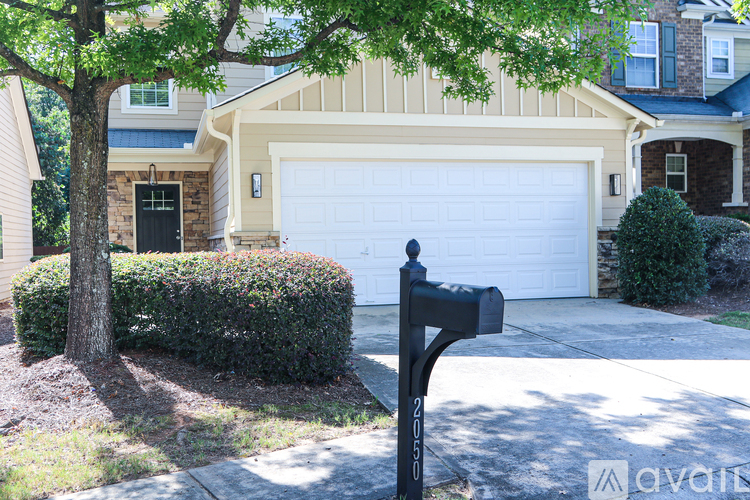 A black mailbox is in front of a white garage door.