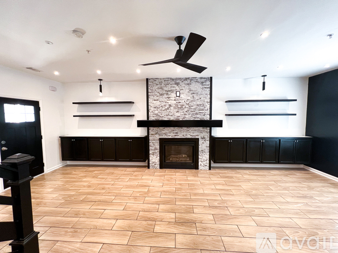 A modern living room with a fireplace and built-in shelves.