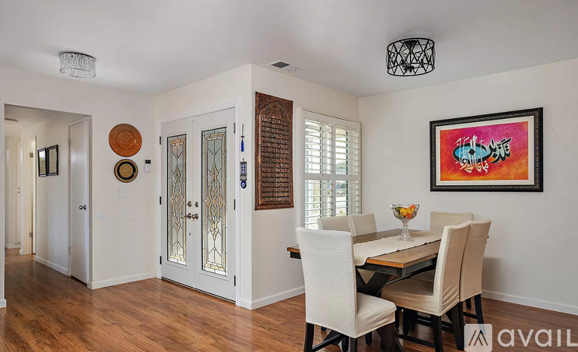 A dining room with a wooden table and chairs.