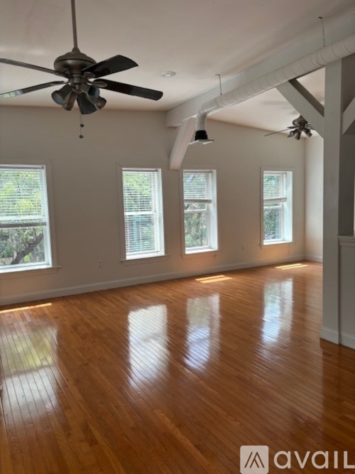 A room with wooden floors and a ceiling fan.