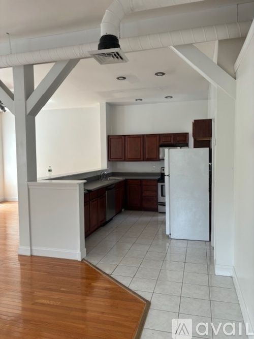 A kitchen with white appliances and wooden floors.