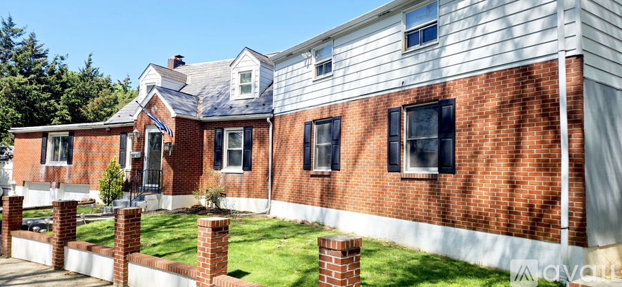 A house with a red brick wall and white trim.
