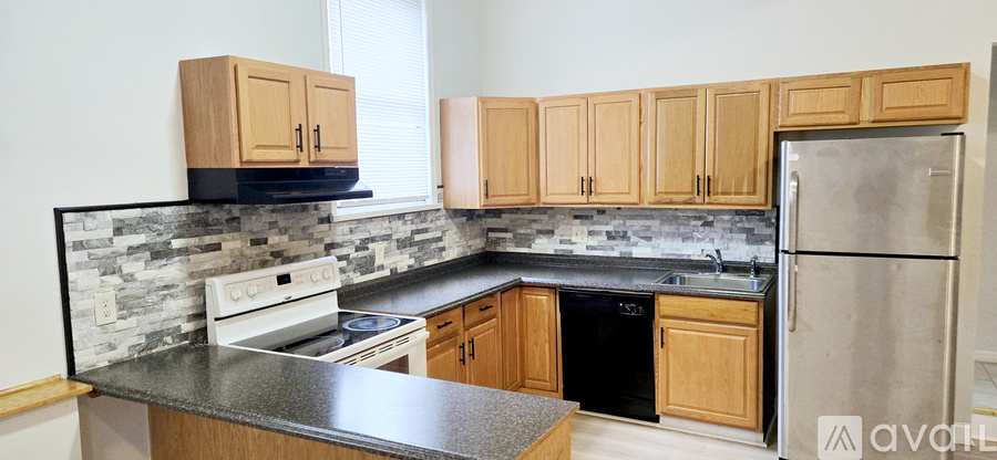 A kitchen with wooden cabinets and a black countertop.