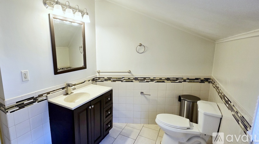 A bathroom with a sink, toilet, and mirror.