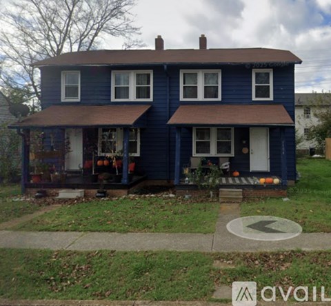 A blue house with a brown roof and a white door.