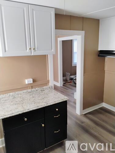 A kitchen with black cabinets and a marble countertop.