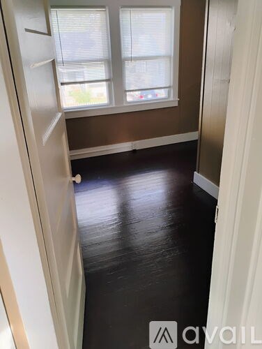 A hallway with a white door and a brown wall.