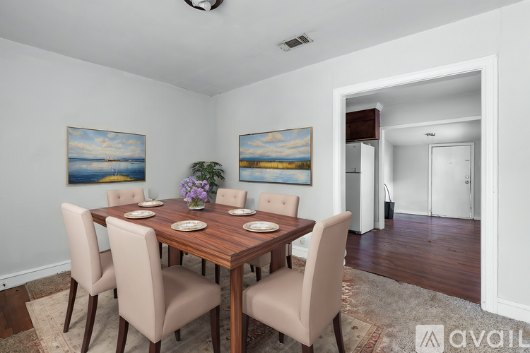 A dining room with a wooden table and chairs.