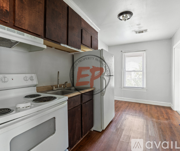 A kitchen with white appliances and wooden cabinets.