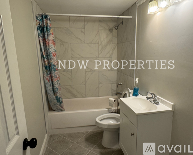 A bathroom with a tub, toilet, and sink.