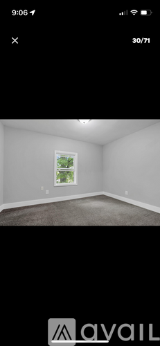 A room with a window and a white wall.