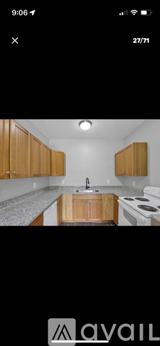A kitchen with wooden cabinets and a white stove top oven.