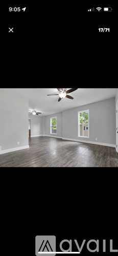 A room with a ceiling fan and wooden flooring.