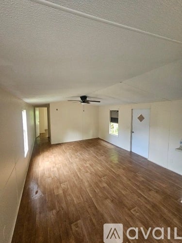 A room with wooden flooring and a ceiling fan.