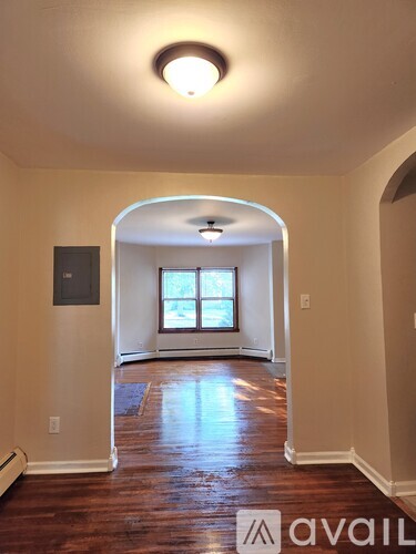 A room with a window and a wooden floor.